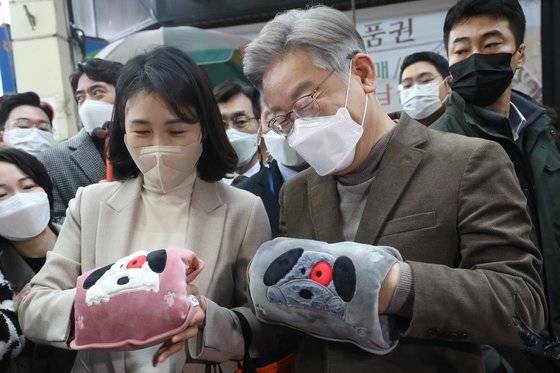 이재명 더불어민주당 대선 후보와 부인 김혜경 씨가 21일 오전 충북 청주시 육거리종합시장에서 워머를 착용하고 있다. 두 사람은 이날 아이보리, 베이지, 갈색 계열의 목폴라·울 소재 자켓을 맞춰입었다. 뉴스1