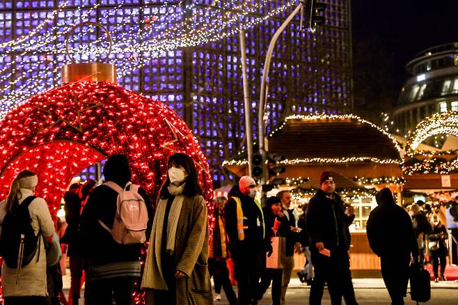 독일 베를린의 한 크리스마스마켓에서 25일(현지시간) 시민들이 마스크를 쓰고 지나가고 있다. 독일은 최근 코로나19 감염이 급증하고 있다. 베를린/EPA연합뉴스