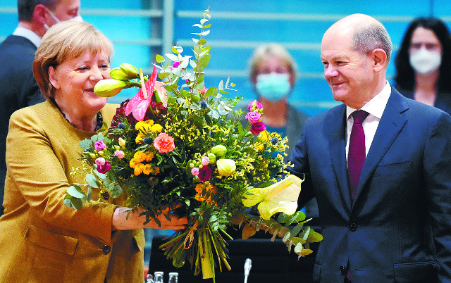 앙겔라 메르켈(왼쪽) 독일 총리가 24일(현지시간) 수도 베를린 총리실에서 열리는 각료회의에 앞서 올라프 숄츠 차기 총리로부터 꽃다발을 받고 있다. 지난 9월 총선에서 승리한 사회민주당(SPD)과 녹색당, 자유민주당(FDP)이 이날 새 연립정부 구성에 합의함에 따라 이번 각료회의는 메르켈 총리의 마지막 회의가 될 것으로 보인다. AFP연합뉴스