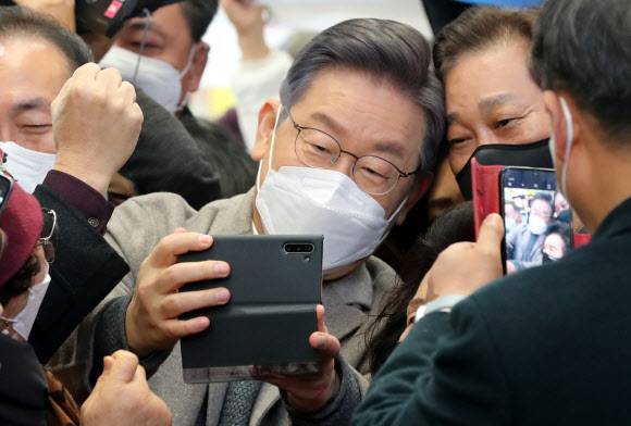 시민들과 머리 맞대고 사진 찍는 이재명 - 더불어민주당 이재명 대선후보가 26일 오전 전남 목포시 동부시장을 방문, 시민들과 사진을 찍고 있다. 2021.11.26 연합뉴스
