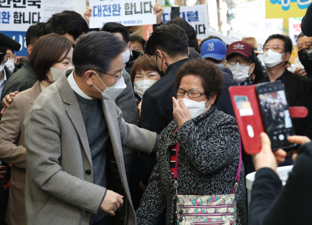 이재명 더불어민주당 대선 후보가 26일 목포 동부시장을 찾아 지지자들과 인사를 나누고 있다. / 연합뉴스
