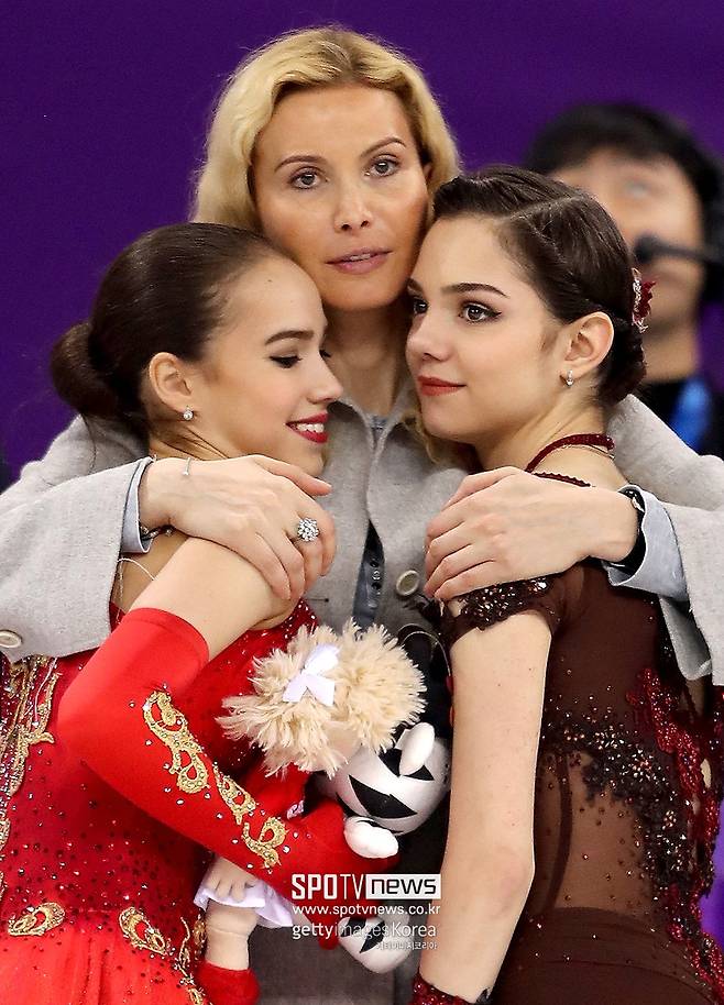 ▲ 2018년 평창 동계 올림픽에서 피겨스케이팅 여자 싱글 금메달리스트인 알리나 자기토바(왼쪽)와 은메달리스트 예브게니아 메드베데바(오른쪽)와 포옹하고 있는 에테리 투트베리제(가운데) 코치