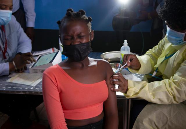 남아공 요하네스버그 인근 마을에 거주하는 한 여성이 지난달 신종 코로나바이러스 감염증(코로나19) 백신을 맞으며 얼굴을 찡그리고 있다. 요하네스버그=AP 연합뉴스