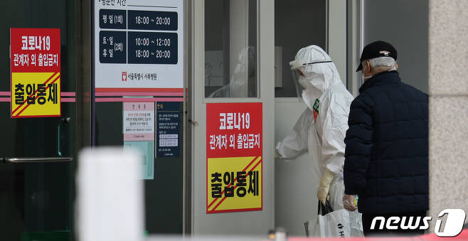 26일 오후 서울 은평구 서울시립서북병원에 코로나19 확진 환자가 도착해 의료진의 안내를 받고 있다.  © News1 박지혜 기자