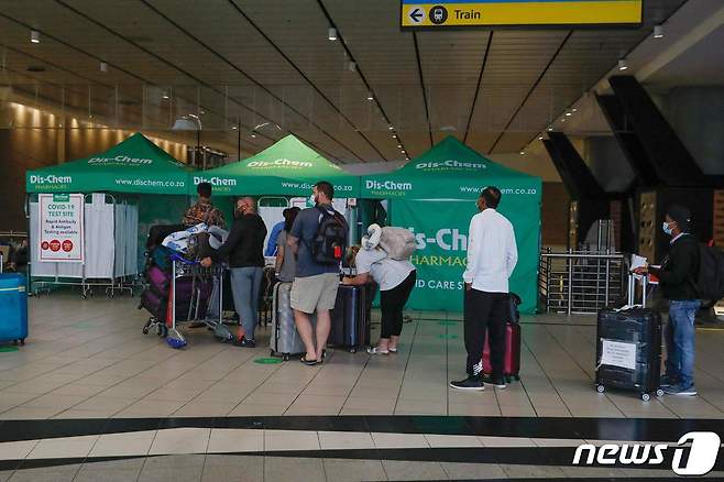남아프리카공화국 요하네스버그 소재 OR탐보 국제공항에서 여행객들이 27일(현지시간) 코로나19 진단검사를 받고 있다. © AFP=뉴스1