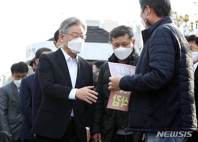 [서울=뉴시스] 최진석 기자 = 이재명 더불어민주당 대선 후보가 15일 오후 서울 세종대로 정부서울청사 앞에 차려진 지역화폐·골목상권살리기 운동본부 농성 현장을 방문해 소상공인 자영업자들과 인사를 나누고 있다. 2021.11.15. myjs@newsis.com