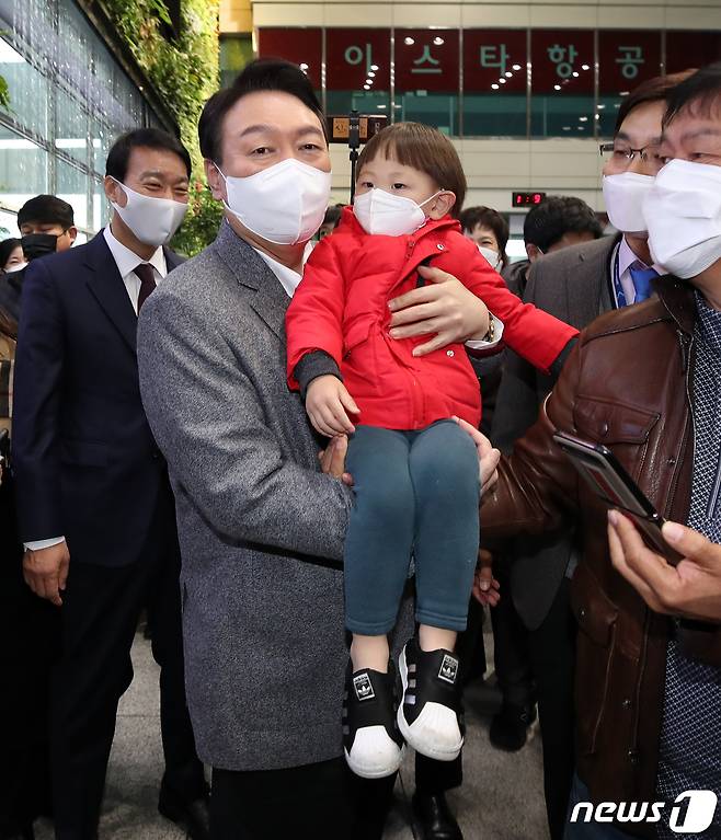 윤석열 국민의힘 대선 후보가 30일 오전 충북 청주시 청주국제공항을 방문해 공항을 찾은 어린이를 안아주고 있다. 2021.11.30/뉴스1 © News1 오대일 기자