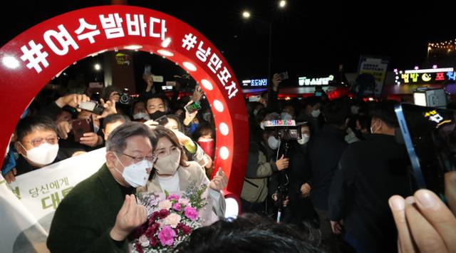 더불어민주당 이재명 대선후보가 생일인 27일 전남 여수시 하멜로 여수 핫플레이스 낭만포차거리를 부인 김혜경씨와 함께 방문, 지지자들에게 하트 인사를 하고 있다. 여수=연합뉴스