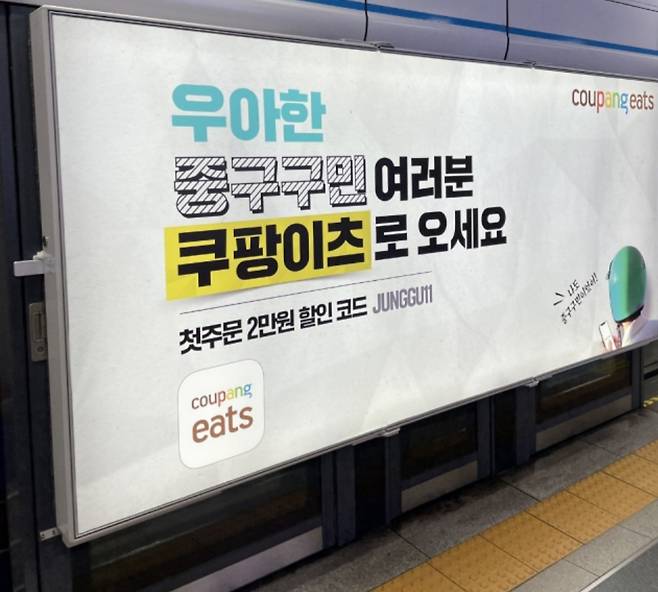 최근 주요 지하철역 플랫폼에 게제된 쿠팡이츠 광고. “우아한 OO구민 여러분 쿠팡이츠로 오세요” 라며 배달의민족 운영사 ‘우아한형제들’을 에둘러 표현하고 있다. [독자 제공]