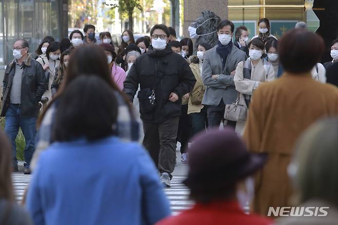 [도쿄(일본)=AP/뉴시스]지난 29일 일본 도쿄에서 코로나19 감염 예방을 위해 마스크를 착용한 시민들이 횡단보도를 건너고 있다. 2021.11.30.