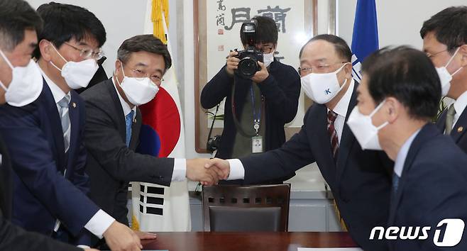 30일 국회 본관 더불어민주당 원내대표실에서 홍남기 경제부총리와 윤호중 원내대표가 예산협의를 위해 만나 악수를 하고 있다. 맹성규 더민주 예결위간사(왼쪽부터), 박완주 정책위의장, 윤 원내대표, 홍 부총리, 안도걸 기재부차관, 최상대 예산실장. 2021.11.30/뉴스1 © News1 이동해 기자