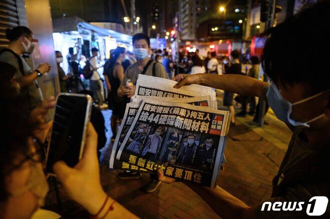 지난 6월18일 홍콩 경찰로부터 압수수색을 당하고 편집국장 등 5명이 체포당한 반중 신문인 빈과일보를 시민들이 들고 있다. © AFP=뉴스1 © News1 우동명 기자