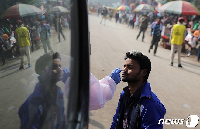 30일 인도 뉴델리의 한 버스 터미널에서 인도 남성이 신종 코로나바이러스 감염증(코로나19) 검사를 받고 있다. © 로이터=뉴스1 © News1 박재하 기자