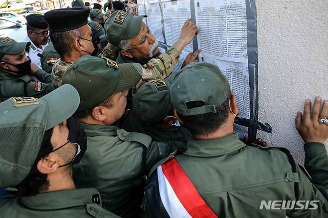 [바그다드=AP/뉴시스] 이라크 총선을 이틀 앞둔 8일(현지시간) 이라크 보안군 관계자들이 사전투표를 하기 위해 바그다드의 한 투표소에 모여들고 있다. 올해 7월 이라크와 미국은 12월31일까지 남은 미군의 완전철수를 합의했다.