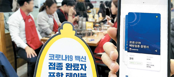 청소년에게도 방역패스를 적용하고 식당·카페 등으로 적용 범위를 넓힌 특별방역대책 후속 조치가 시행됐지만 사회적 반발이 거세다. 6일 서울의 한 식당에서 직장인들이 방역패스를 제시한 뒤 식사를 하고 있다. [김호영 기자]