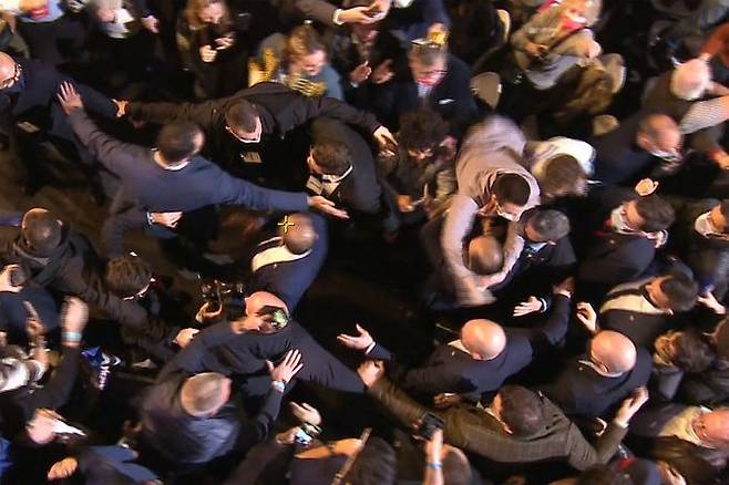 5일(현지시간) 프랑스 파리 외곽 빌팽트에서 열린 대통령 선거 후보 에릭 제무르(63)의 첫 유세에서 한 남성이 두 팔로 제무르의 목을 낚아채고 있다. 제무르는 목이 감긴 채 잠시 끌려갔으나 경호원들의 제지로 풀려났다. 빌팽트 AFP=연합뉴스