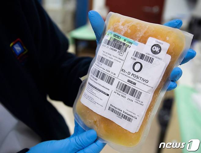 한 연구원이 신종 코로나바이러스 감염증 완치자가 기부한 피가 담긴 냉동봉지를 들고 있다. 2020.10.05 © AFP=뉴스1