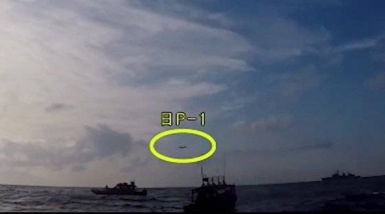 2018년 12월 20일 조난 선박 구조작전 중인 해군 광개토대왕함 상공에 일본 초계기(노란 원)가 저공으로 비행하고 있다. 일본은 명확한 이유를 밝히지 않은채 한국의 잘못이라고만 주장하고 있다. 국방부 유튜브 캡처=연합