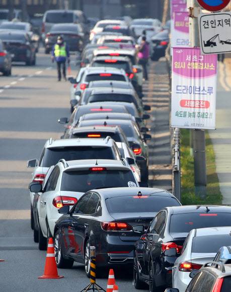 코로나19 확산세, 드라이브스루 검사소는 장사진 - 국내 신종 코로나바이러스감염증(코로나19) 신규 확진자수가 월요일 기준 역대 최다를 기록한 7일 오전 서울 서초구 드라이브스루 임시 선별검사소를 찾은 차들이 줄지어 대기하고 있다. 2021.12.7 연합뉴스