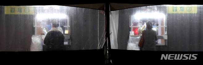 [서울=뉴시스] 조수정 기자 = 8일 밤 서울 중구 서울광장 코로나19 임시선별검사소에서 시민들이 늦은 시간 코로나19 검사를 받고 있다. 이날 0시 기준 코로나19 신규확진자 수(전날 추가 발생)는 7175명으로 국내 코로나19 유입 이후 처음으로 7000명대를 기록했다. 이날 오후 6시 기준 코로나19 확진자 수는 3631명으로 전날 같은시간보다 518명 적은 것으로 집계됐다. 2021.12.08. chocrystal@newsis.com