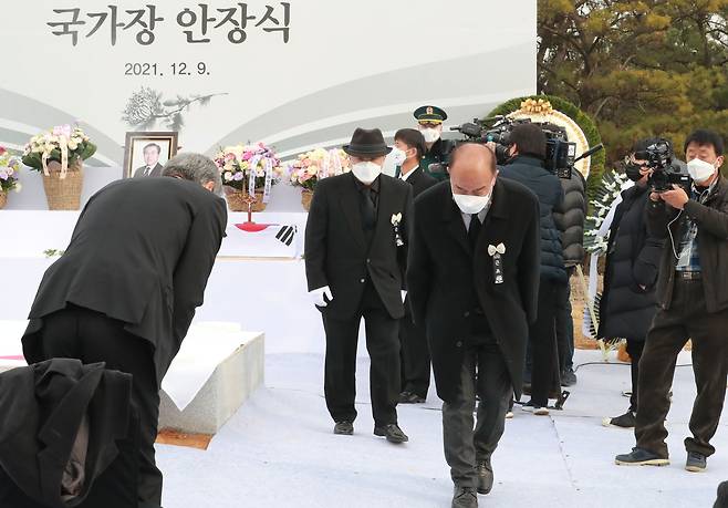 박남선 5·18 당시 시민군 상황실장이 헌화를 마치고 아들 노재헌 동아시아문화센터 이사장과 인사하고 있다.  우상조 기자