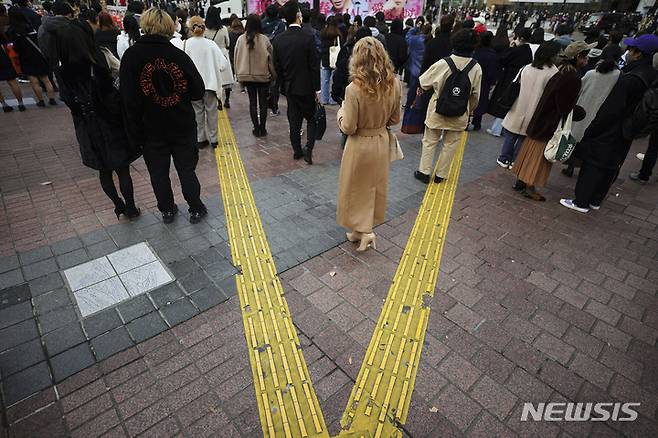 [도쿄=AP/뉴시스] 10일 일본 도쿄의 시부야 쇼핑거리에서 시민들이 횡단보도를 건너기 위해 기다리고 있다. 2021.12.10
