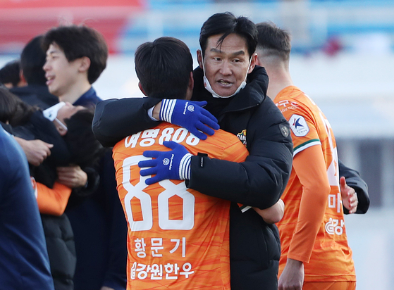 Gangwon FC head coach Choi Yong-soo embraces Hwang Mun-ki after beating Dajeon Hana Citizen 4-1 in the second leg of the promotion-relegation playoff on Sunday at Gangneung Stadium in Gangneung, Gangwon. [NEWS1]