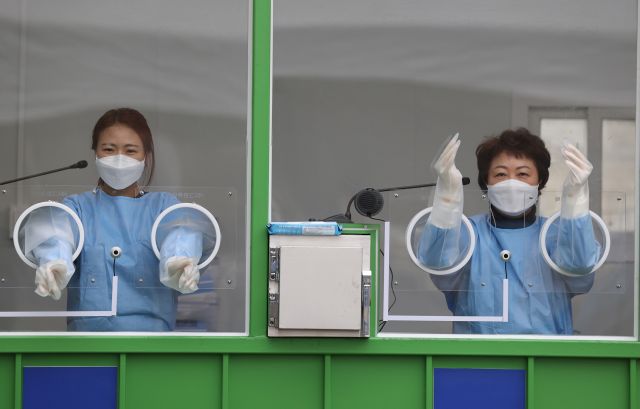 지난 10일 오후 서울 마포구 월드컵공원 평화광장에 설치된 코로나19 거점형 검사소에서 관계자들이 검사 준비를 하고 있다. 연합뉴스