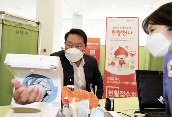 최태원 SK 회장(왼쪽)이 지난해 5월 서울 중구 SK텔레콤 T타워에서 열린 구성원 헌혈 릴레이에서 헌혈하는 모습.  [사진 제공 = SK]