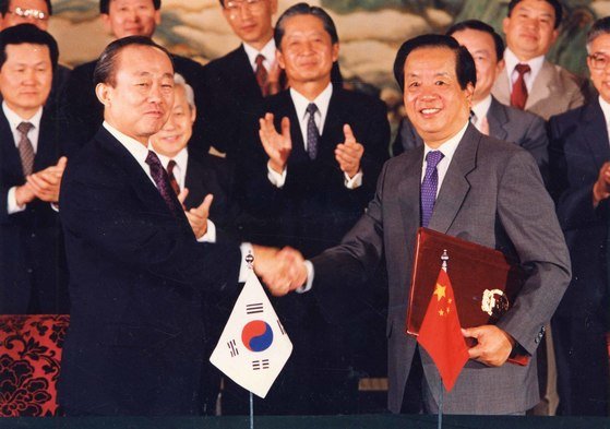 이상옥 한국 외무장관(왼쪽)과 첸지첸 중국 외교부장이1992년 8월 24일 북경에서 한중수교 공동성명서를 교환하고 악수를 나누는 모습. [중앙포토]