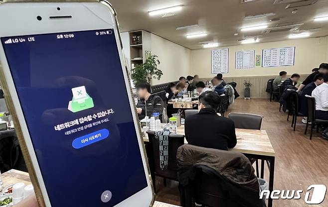방역패스 시행 둘째날인 14일 코로나19 백신 접종 여부를 확인할 수 있는 앱이 이틀 연속 장애를 겪고 있다. 사진은 이날 서울 여의도의 한 식당에서 먹통이 된 방역패스 앱의 모습. 2021.12.14/뉴스1 © News1 이승배 기자