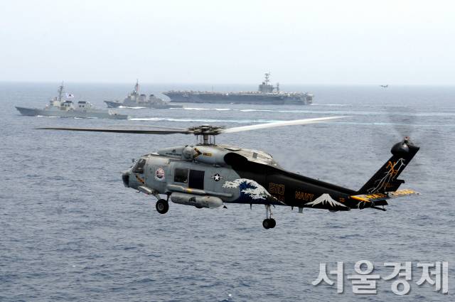 우리 해군 구축함 세종대왕함이 지난 2012년 6월 22일(현지시간) 동중국해에서 미 해군 항공모함 및 일본 자위대 구축함과 연합훈련을 하는 가운데 시호크 헬리콥터가 대잠초계비행을 하고 있다. 미국은 한국, 일본과의 삼각동맹을 역내 안보질서를 지킬 핵심축으로 규정하고 있지만 한일관계 갈등이 불안요인으로 작용하고 있다. 사진제공=미 해군