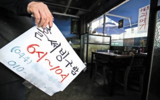 정부가 강화된 방역 대책을 발표한 지난 16일, 대전 유성구의 한 식당 주인이 직원 구인 안내문을 떼 매장으로 들어가고 있다. 코로나19 확산에 아르바이트 등 일용근로자 수가 크게 줄었다. [뉴스1]