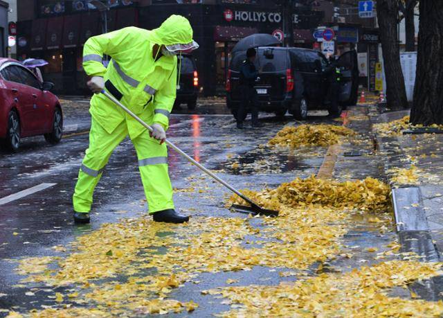 가을비가 폭우처럼 쏟아진 지난달 19일 오전 서울 광화문 사거리 인근에서 환경미화원이 빗물에 젖은 낙엽을 치우고 있다. 홍인기 기자