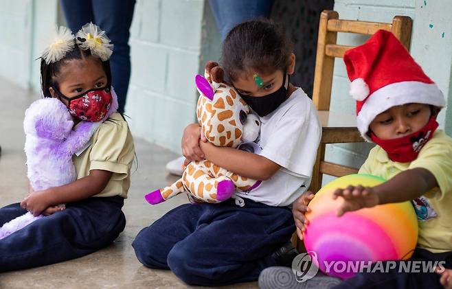 선물 받은 인형 끌어안는 아이들  [EPA 연합뉴스 자료사진. 재판매 및 DB 금지]