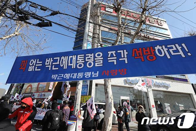 5일 오전 대구 달서구 감삼동 조원진 대한애국당 의원 사무실 앞에서 대한애국당원과 지지자를 비롯한 보수시민단체 회원들이 ‘평양올림픽 반대’ 집회를 열고 있다. 횡단보도 앞 가로수에 박근혜 전 대통령 석방을 촉구하는 플래카드가 걸려 있다. 2018.2.5/뉴스1 © News1 공정식 기자