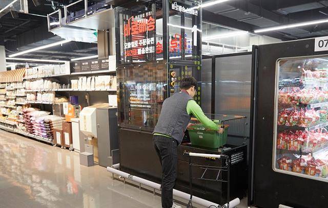 롯데마트 광교점 직원이 온라인으로 들어온 주문 상품을 전용 바구니에 담아 수직 리프트(피킹 스테이션)에 넣고 있다. 기존 점포를 물류센터처럼 활용하는 롯데마트는 신선식품의 경우 2시간 이내 배송이 가능하다고 설명한다. 롯데쇼핑 제공