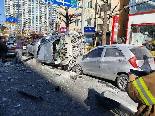 30일 부산 연산동 홈플러스  5층 주차장에서 택시가 벽을 뚫고 도로로 떨어져 신호대기 중인 차량 10여대를 덮쳤다. 부산경찰청 제공