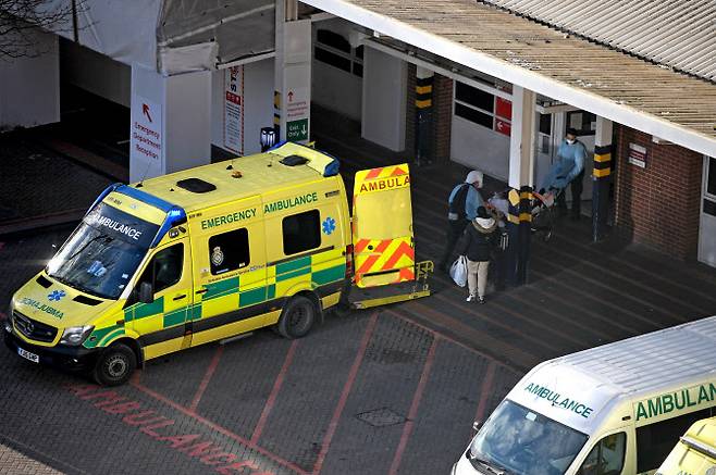 구급대원들이 5일(현지시간) 영국 북부 리즈의 리즈 종합의료병원에 도착한 뒤 구급차에서 환자를 내리고 있다. 영국 병원들은 오미크론 감염으로 인한 인력 부족으로 최근 ‘전시 체제’로 전환했다. (사진=AFP)