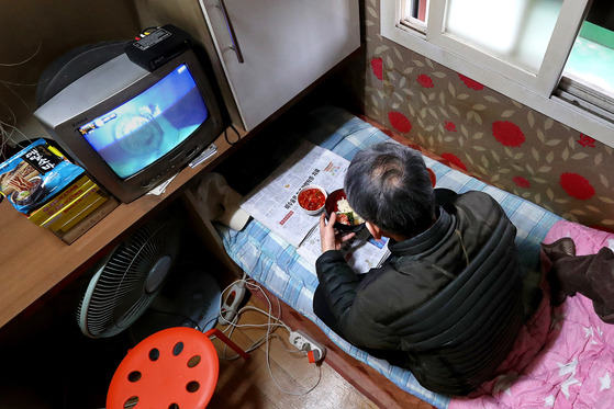 A man eats breakfast alone at a gosiwon, or a very small room rented out cheaply to students preparing for exams, on New Year’s Day in 2019. [JANG JIN-YOUNG]