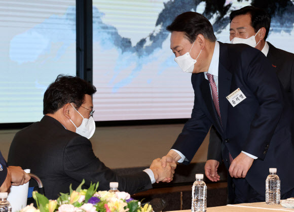 인사하는 윤석열-송영길 - 국민의힘 윤석열 대선 후보(오른쪽)와 더불어민주당 송영길 대표가 5일 서울 여의도 중소기업중앙회관에서 열린 2022 중소기업인 신년 인사회에서 인사를 나누고 있다. 2022.1.5 연합뉴스