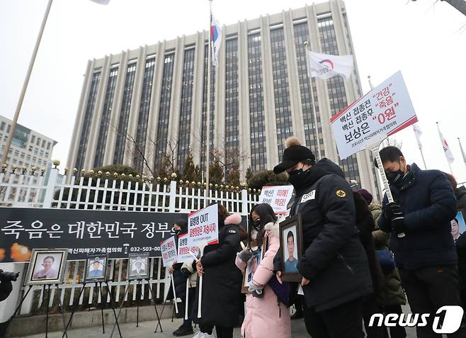 8일 오후 서울 종로구 정부서울청사 앞에서 코로나19백신피해자가족협의회(코백회) 주최로 열린 코로나19 백신피해 인가성 인정 촉구 집회에서 유가족들이 묵념을 하고 있다. 코백회는 지난해 말부터 매주 토요일마다 코로나19 백신 부작용을 호소하고 정부의 방역패스를 비판하는 집회를 해 왔다. 코백회 관계자는 "가족을 잃고, 백신 부작용을 경험한 사람들이 어떻게 방역패스를 찬성할 수 있겠냐＂며 ＂회원 수가 200명에서 500명으로 크게 늘었다＂고 밝혔다. 2022.1.8/뉴스1 © News1 ,송원영 기자