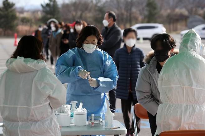 14일 오전 전남 함평군 함평읍 함평엑스포공원 주차장에 마련된 임시 선별검사소에서 의료진이 코로나19 검사를 하고 있다. 오미크론 변이 확진자가 지난 12일 첫 확인된 이후 함평읍은 주민들을 대상으로 전수조사 중이다. 함평=연합뉴스