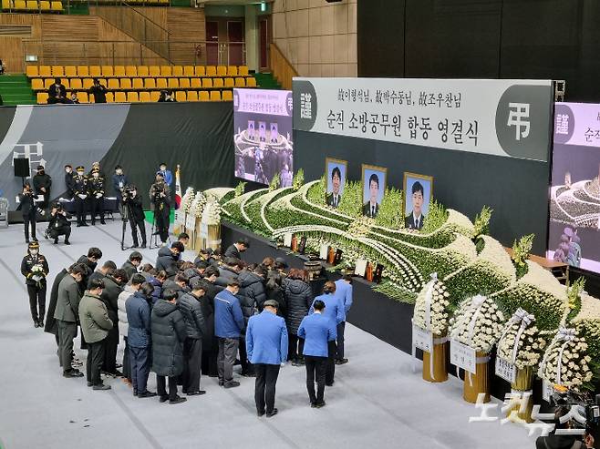 8일 경기도 평택 냉동창고 화재 현장에서 순직한 소방관들의 합동 영결식에서 유족들이 헌화 뒤 묵념을 하고 있다. 정성욱 기자