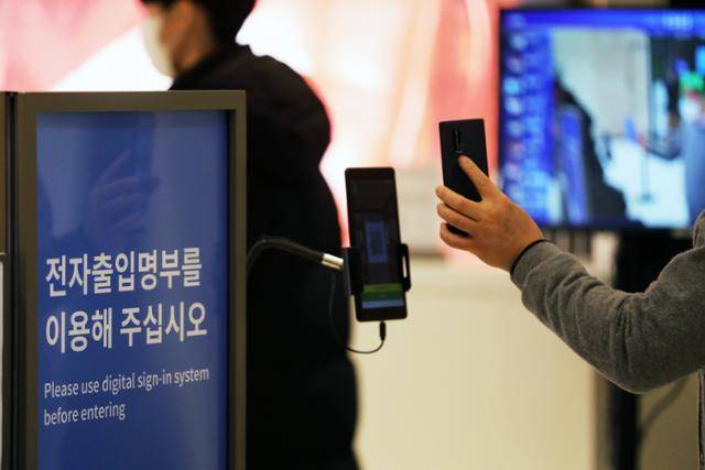 9일 서울 시내 한 백화점에서 고객들이 입장 전 QR코드 체크인을 하고 있다. 뉴스1