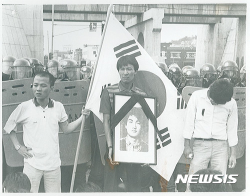 [서울=뉴시스] 경찰이 쏜 최루탄에 맞아 사망한 이한열 열사의 영정사진을 들고 있는 우상호 더불어민주당 의원(사진 앞줄 가운데·당시 연세대 총학생회장)의 모습. (사진=뉴시스DB) 2017.06.08 photo@newsis.com