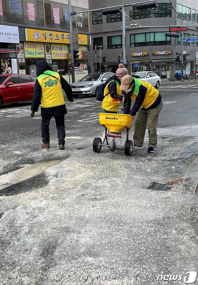 용인시 기흥구 주민들로 구성된 바로바로 기동대가 빙판길에 제설제를 뿌리고 있다.(용인시 제공) © News1