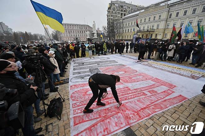 8일(현지시간) 러시아의 침공 가능성 고조 속 우크라이나 키예프에서 시민이 블라디미르 푸틴 러시아 대통령을 비난하는 거대한 플래카드를 만들고 있다. © AFP=뉴스1 © News1 우동명 기자