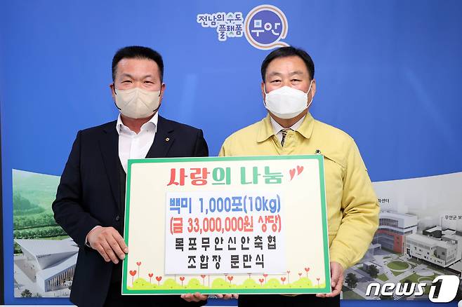 문만식 목포무안신안축협조합장(왼쪽)이 백미 1000포를 무안군에 기탁했다.© 뉴스1