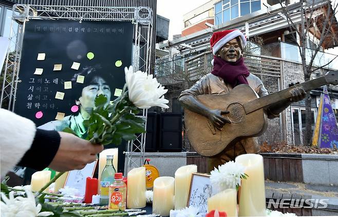 [대구=뉴시스] 이무열 기자 = '영원한 가객' 김광석 26주기 추모식이 열린 6일 오후 대구 중구 '김광석 다시 그리기 길'에서 참가자가 헌화하고 있다. 2022.01.06. lmy@newsis.com